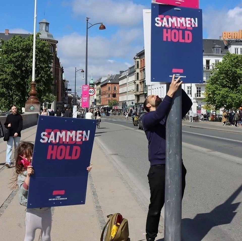 Ruben Kidde hænger plakater op på Dronning Louises bro i København