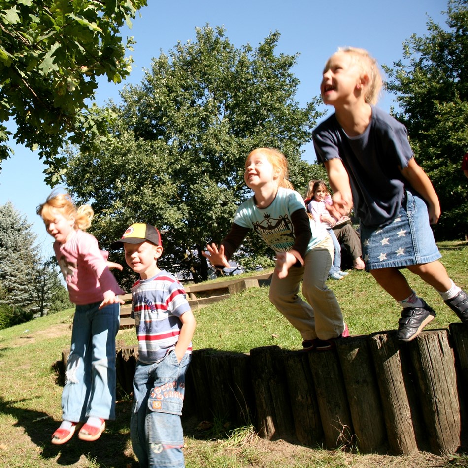 Fire børn hopper på en legeplads