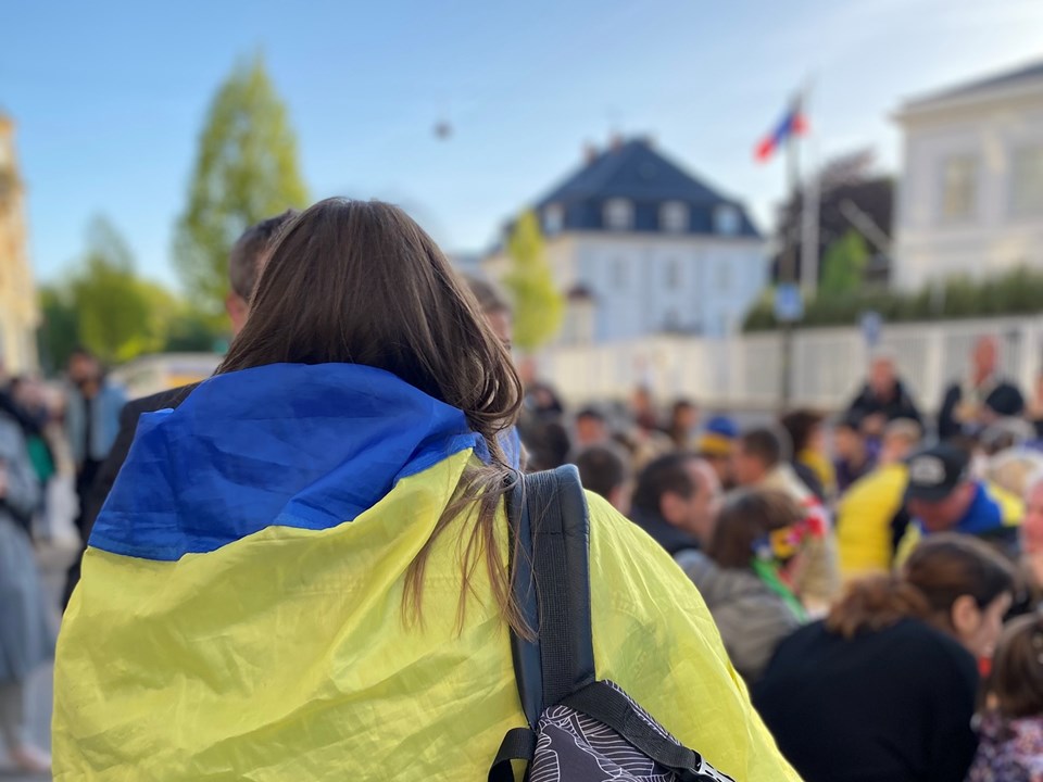 Person med Ukraines flag svøbt om skuldrene ved radikalt arrangement foran Ruslands ambassade