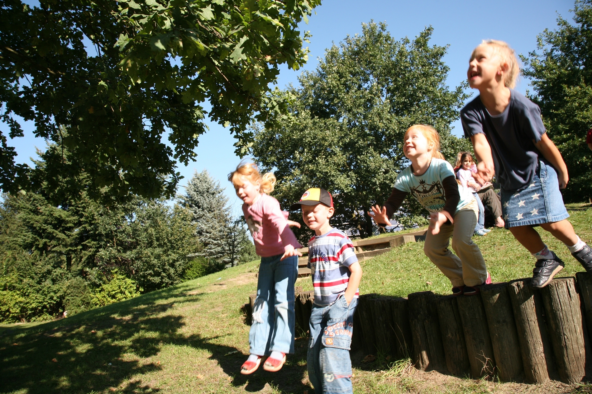 Fire børn hopper på en legeplads