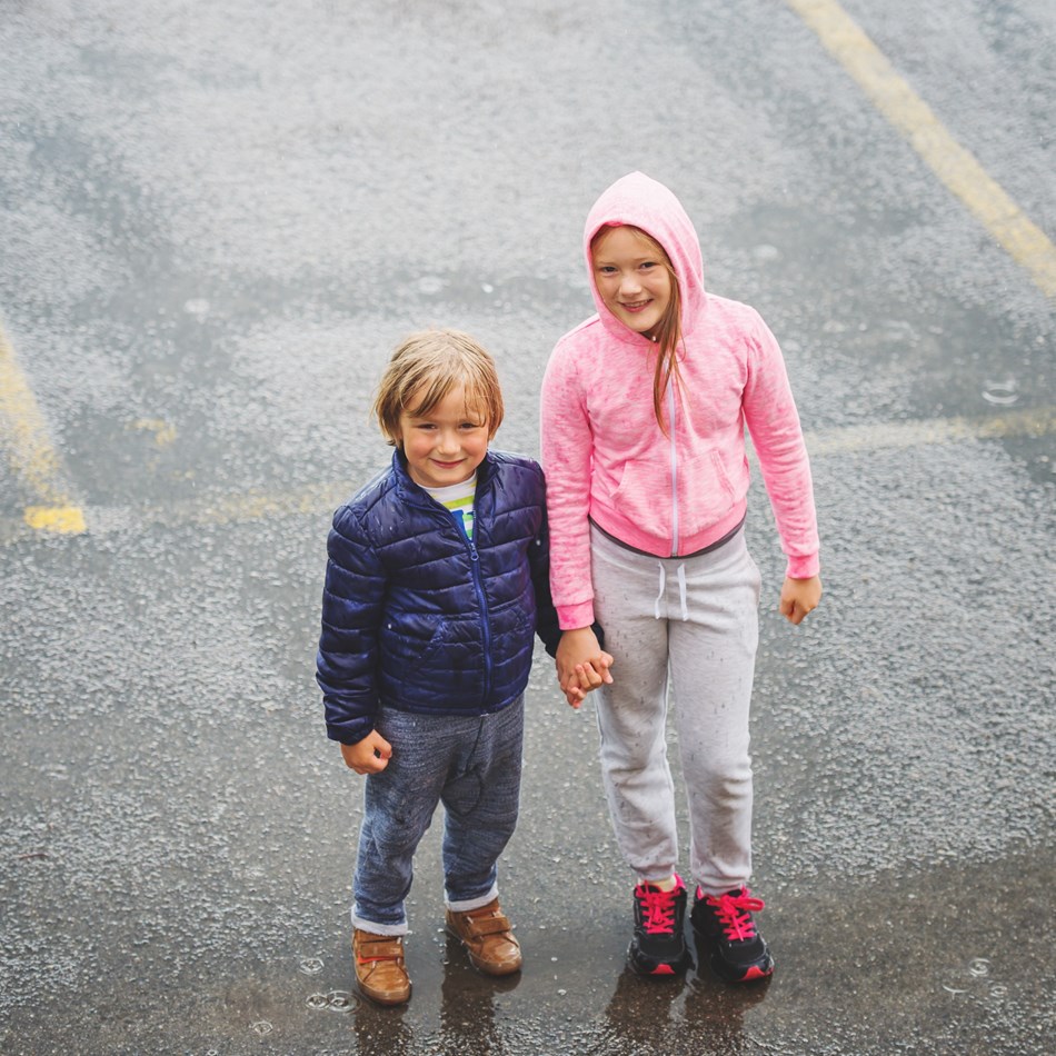 To børn står på en parkeringsplads